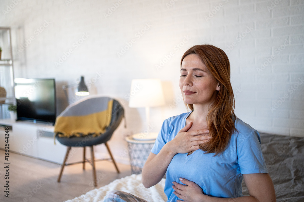 Serene woman practicing deep breathing exercise at home Serene woman practicing deep breathing exercise at home