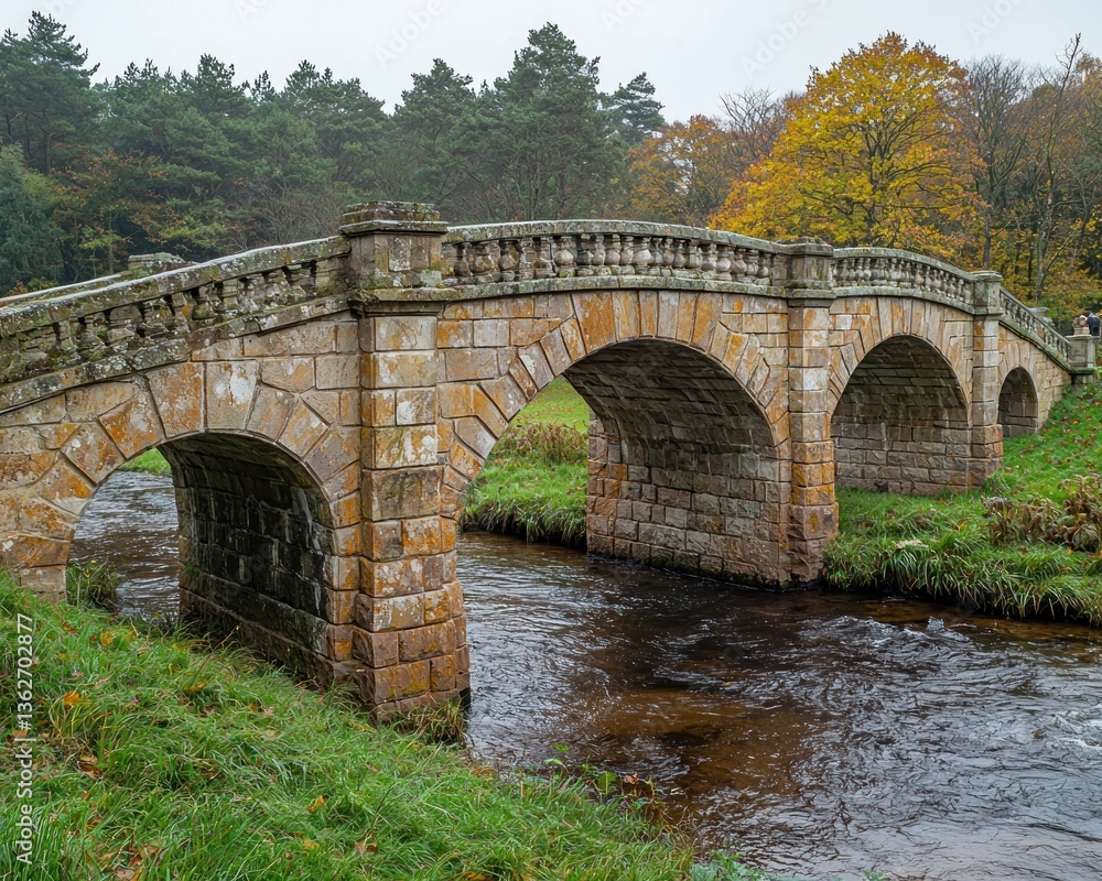 Fototapeta premium Stone Bridge Over Stream in Autumnal Woodland