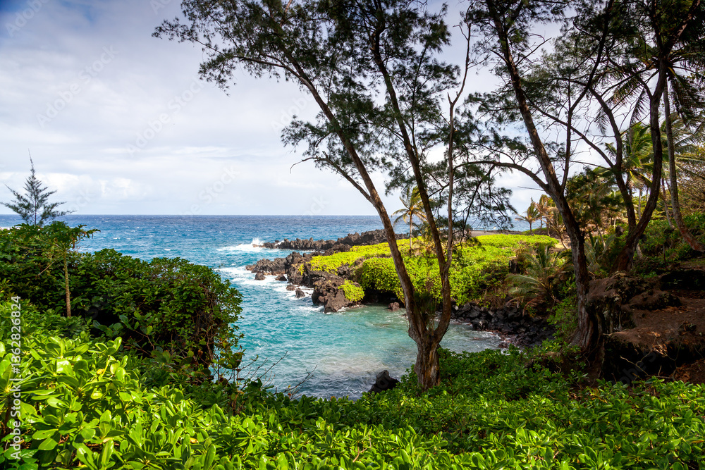 Naklejka premium Beautiful coastline in Hana, Maui, Hawaii with turquoise water and gentle waves hitting volcanic rock formations