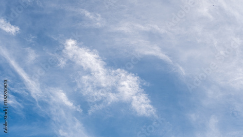 Fotografie Serene view of a vibrant blue sky adorned with soft, delicate white clouds on a bright day