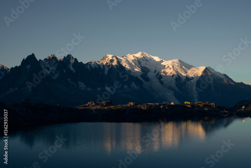 Peaks of the Mont Blanc massif illuminated in morning sunlight and reflected in Lac Blanc
