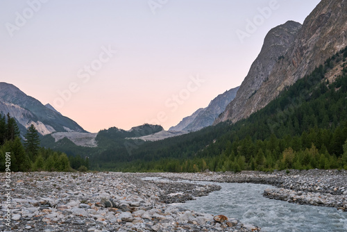 Stream of water in Val Veny with sunrise illuminating surroundings in the morning photo