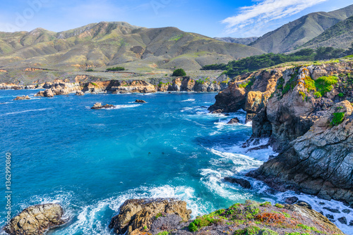 Stunning coastal landscape along California's Highway 1, featuring rugged rocky formations, and the vast blue ocean. A breathtaking natural scene showcasing the raw beauty of the Pacific coastline