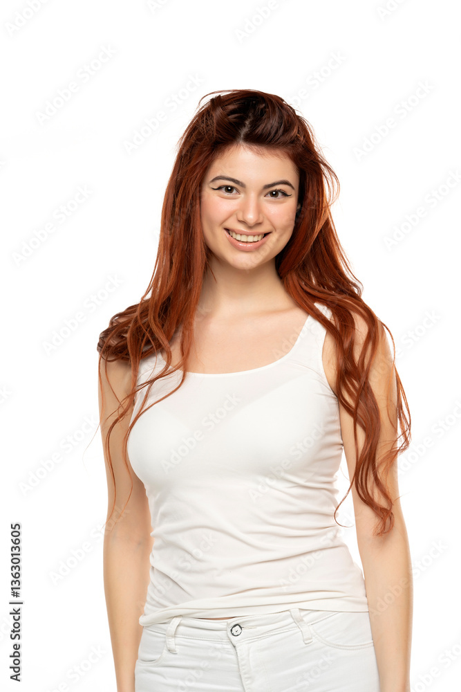 Smiling young woman with long red hair, wearing white tank top. Isolated on white background Smiling young woman with long red hair, wearing white tank top. Isolated on white background