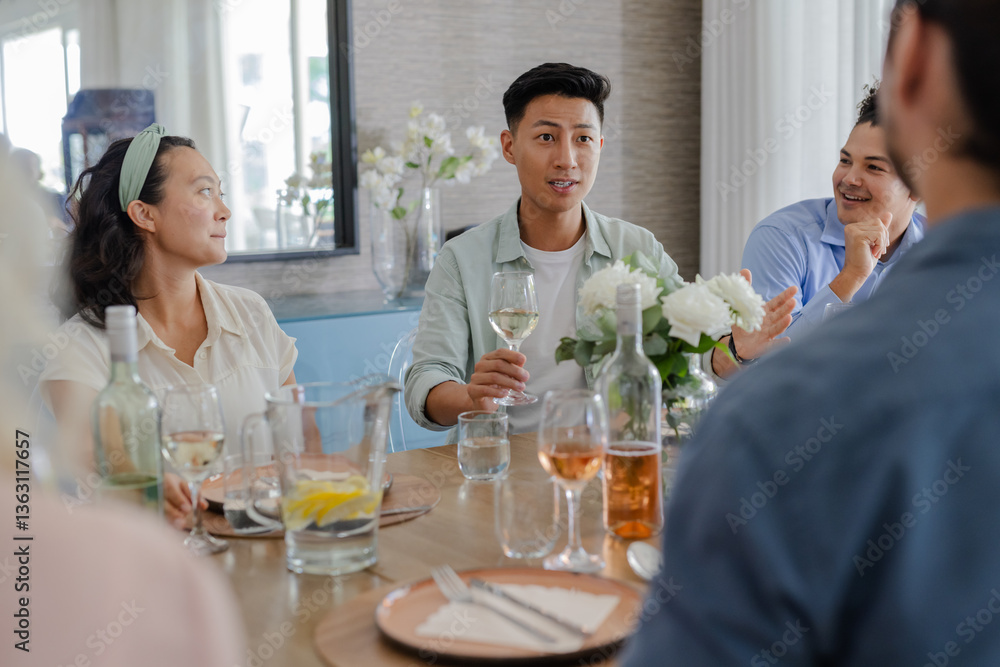 Friends enjoying conversation and drinks at elegant small casual wedding reception table, at home Friends enjoying conversation and drinks at elegant small casual wedding reception table, at home