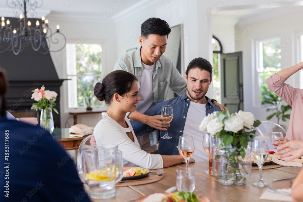 Friends enjoying drinks and conversation at home during small casual wedding celebration, at home Friends enjoying drinks and conversation at home during small casual wedding celebration, at home