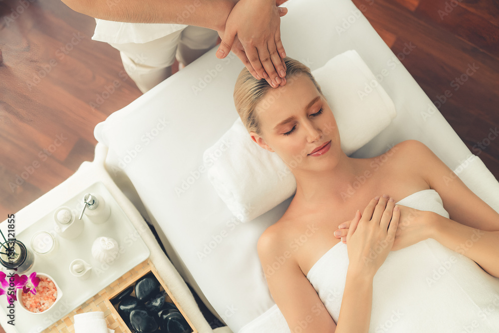 Obraz premium Panorama top view of woman enjoying relaxing anti-stress head massage and pampering facial beauty skin recreation leisure in dayspa modern light ambient at luxury resort or hotel spa salon. Quiescent