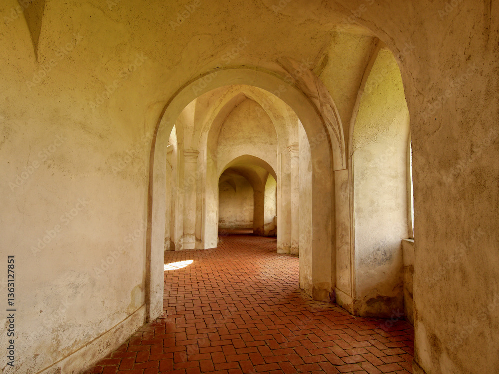 Obraz premium Cobblestone corridor in the arcade of the castle with vaults