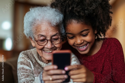 Grandmother and granddaughter smiling at phone	