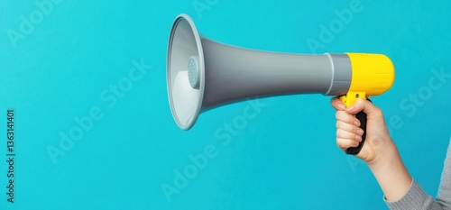 Hand holding megaphone against blue background	