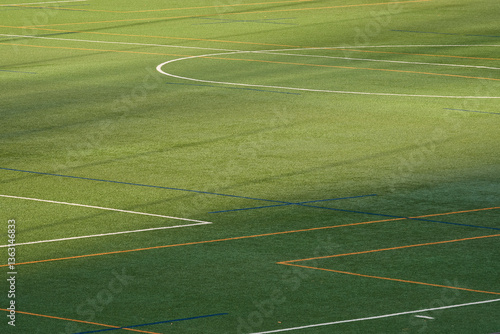 A top-down image of a multi-purpose artificial turf sports field with colorful line markings for various games. 