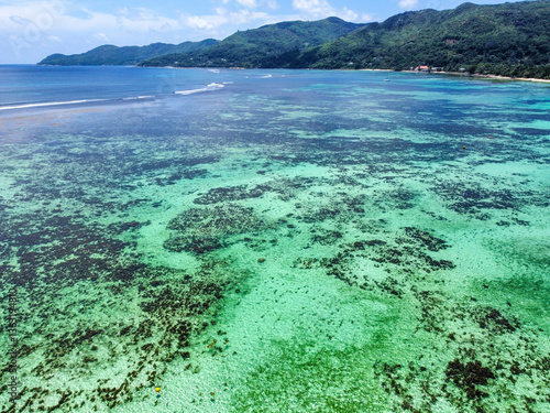 Aerial view of turquoise water and coral reef in a tropical beach