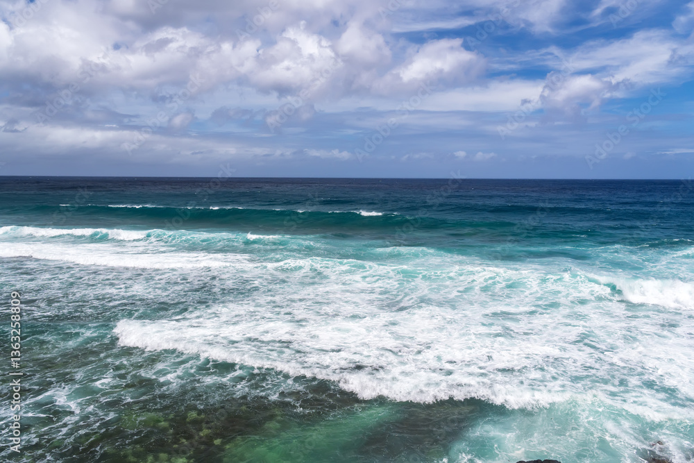 Turquoise ocean waves breaking on tropical shoreline. Coastal view of crystal clear ocean waves with white foam.Pristine seascape Turquoise ocean waves breaking on tropical shoreline. Coastal view of crystal clear ocean waves with white foam.Pristine seascape