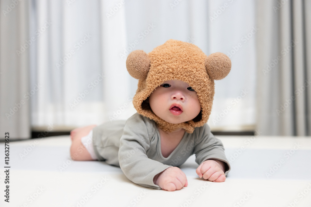 Cute little baby in fluffy bear hat indoor