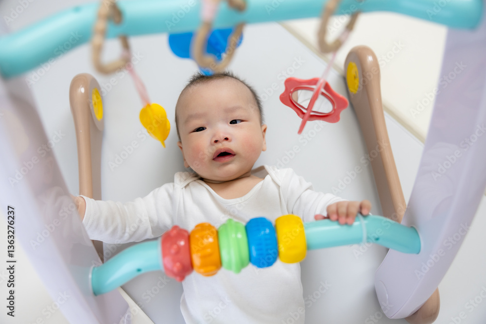 Baby having fun playing on activity gym