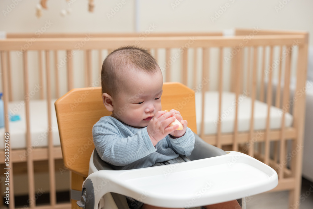 Baby sitting in high chair eating food