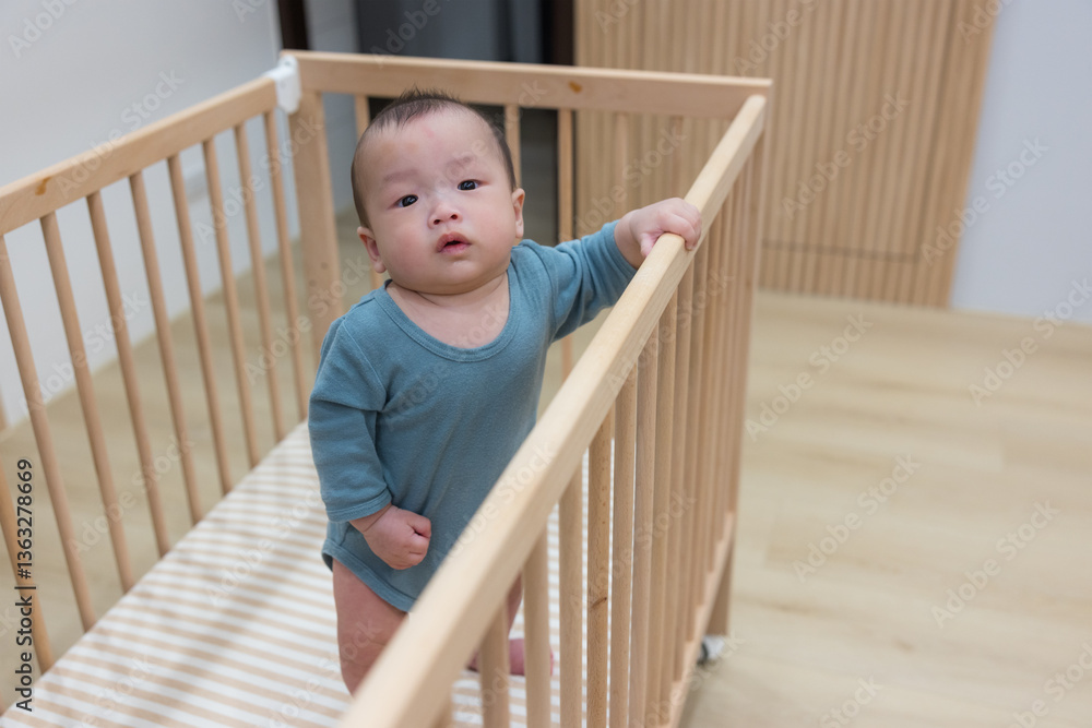 Curious infant standing in safe baby crib Curious infant standing in safe baby crib