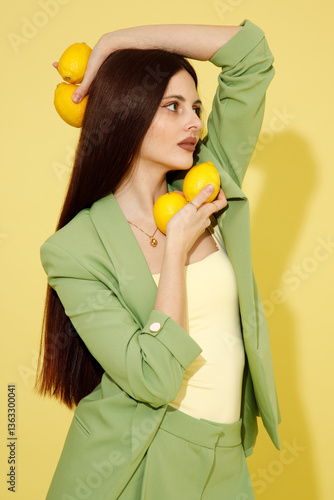 Obraz na płótnie Fashion portrait of beautiful model in green suit with lemons against yellow background w salonie