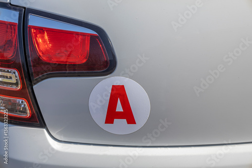 Red letter A sticker displayed on a car's bumper new driver