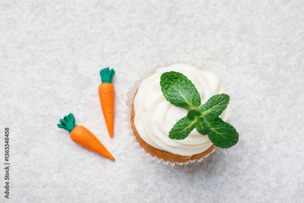 Delicious carrot cupcake with mint on light textured table, flat lay Delicious carrot cupcake with mint on light textured table, flat lay