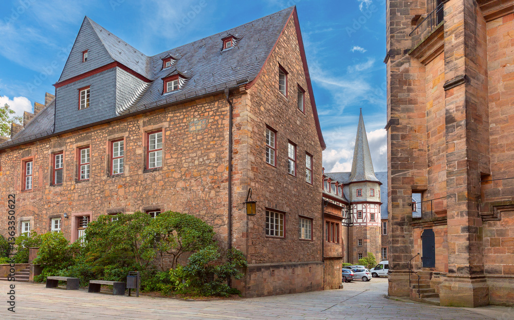 Stone and fachwerk buildings in the old town of Marburg Germany with church wall and tower