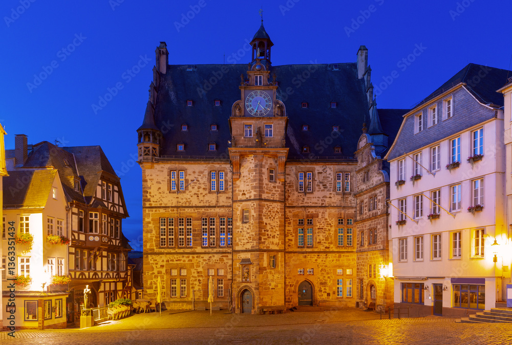 Historic town hall on the illuminated market square in Marburg Germany with surrounding buildings