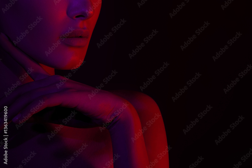 © Mirrorstudio - Close-up of female in red and purple light with subtle expression © Mirrorstudio - Close-up of female in red and purple light with subtle expression