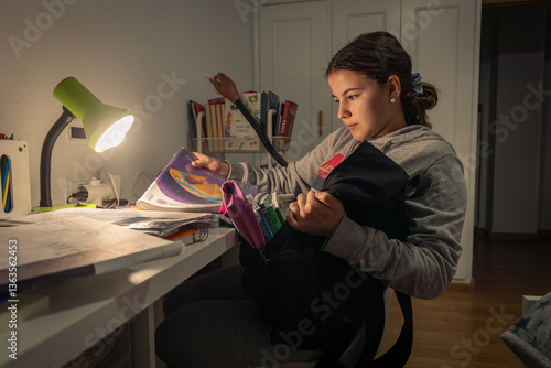 young teenage woman studying in her room