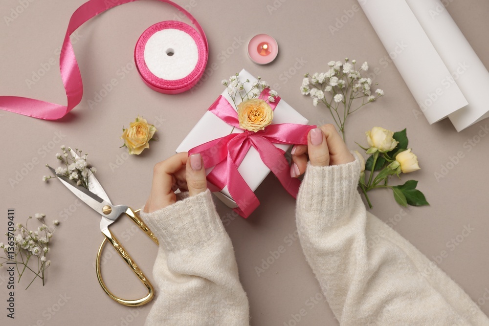 Florist with gift box, flowers, scissors and ribbon on beige background, top view Florist with gift box, flowers, scissors and ribbon on beige background, top view