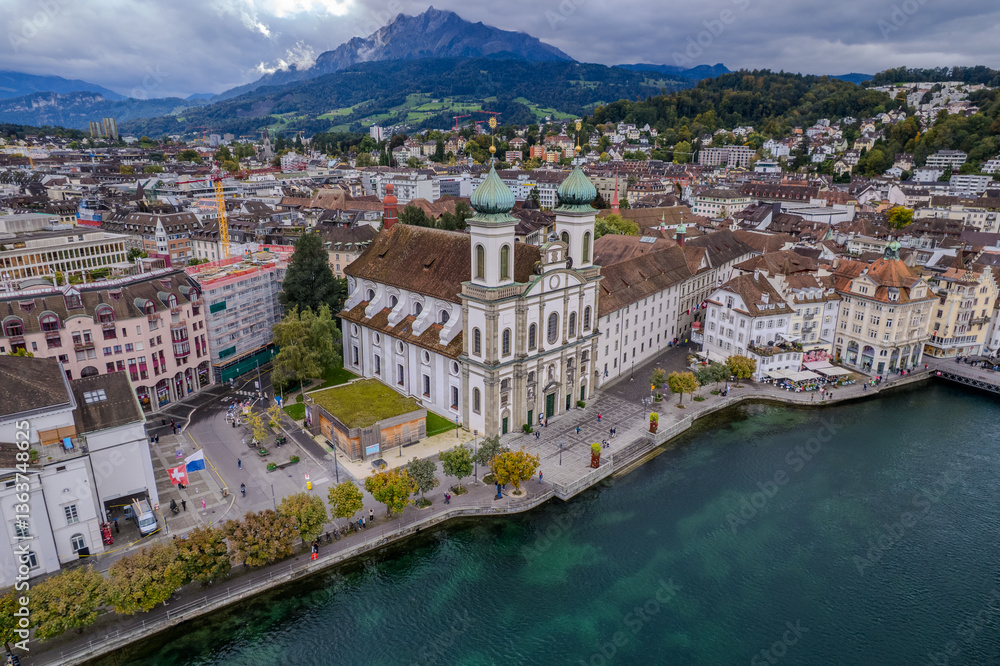 Fototapeta premium Stunning aerial footage of Kapellbrücke, the iconic Chapel Bridge, showcasing the picturesque beauty of Lucerne, Switzerland.