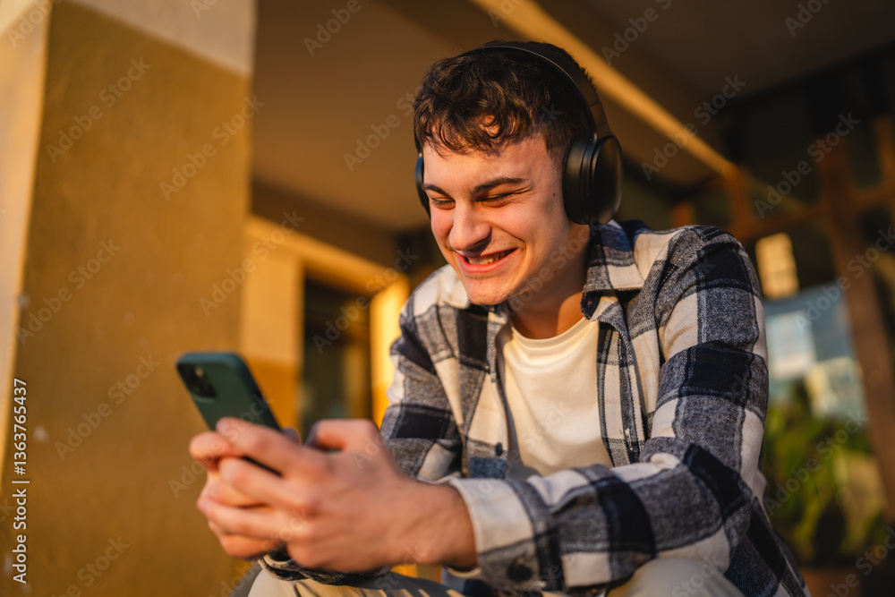 Fototapeta premium young man student sit in front university listen music and enjoy
