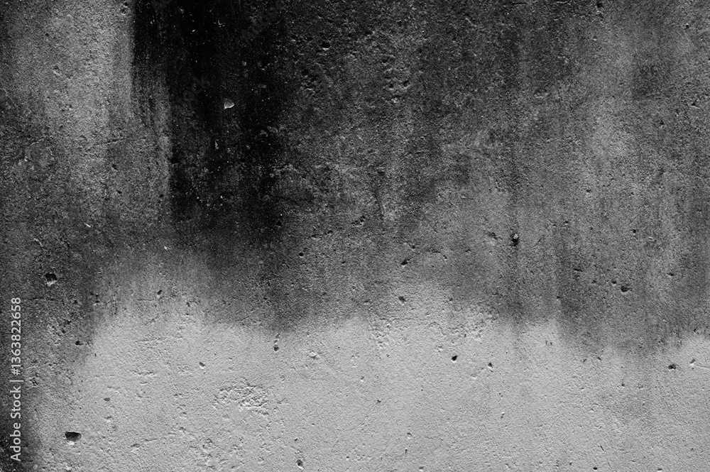 Dark, weathered concrete surface with rough textures and organic patterns, evoking a sense of decay and industrial rawness in a monochrome abstract composition.
