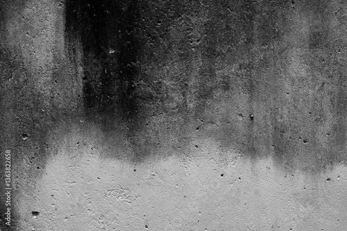 Dark, weathered concrete surface with rough textures and organic patterns, evoking a sense of decay and industrial rawness in a monochrome abstract composition.