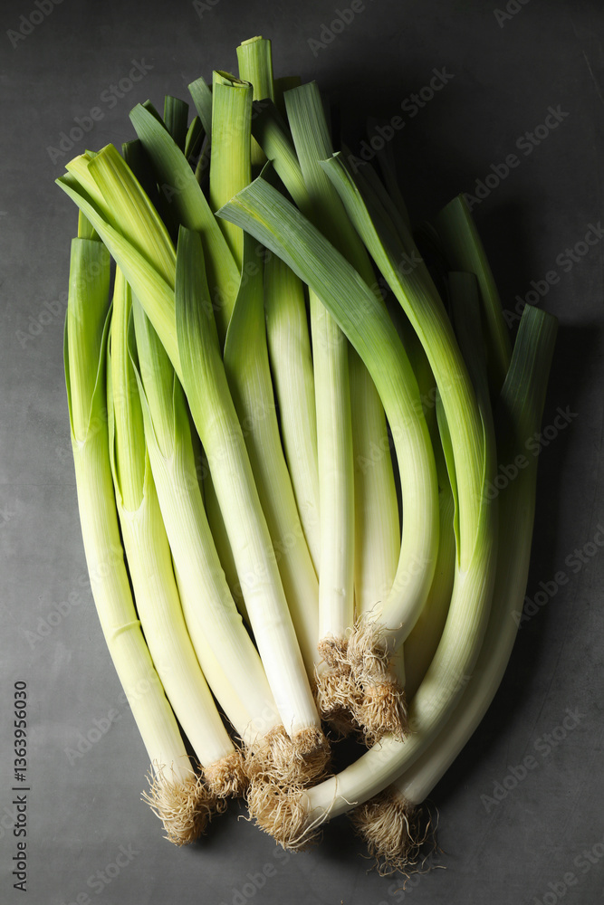 Obraz premium Fresh green leeks on grey table, top view