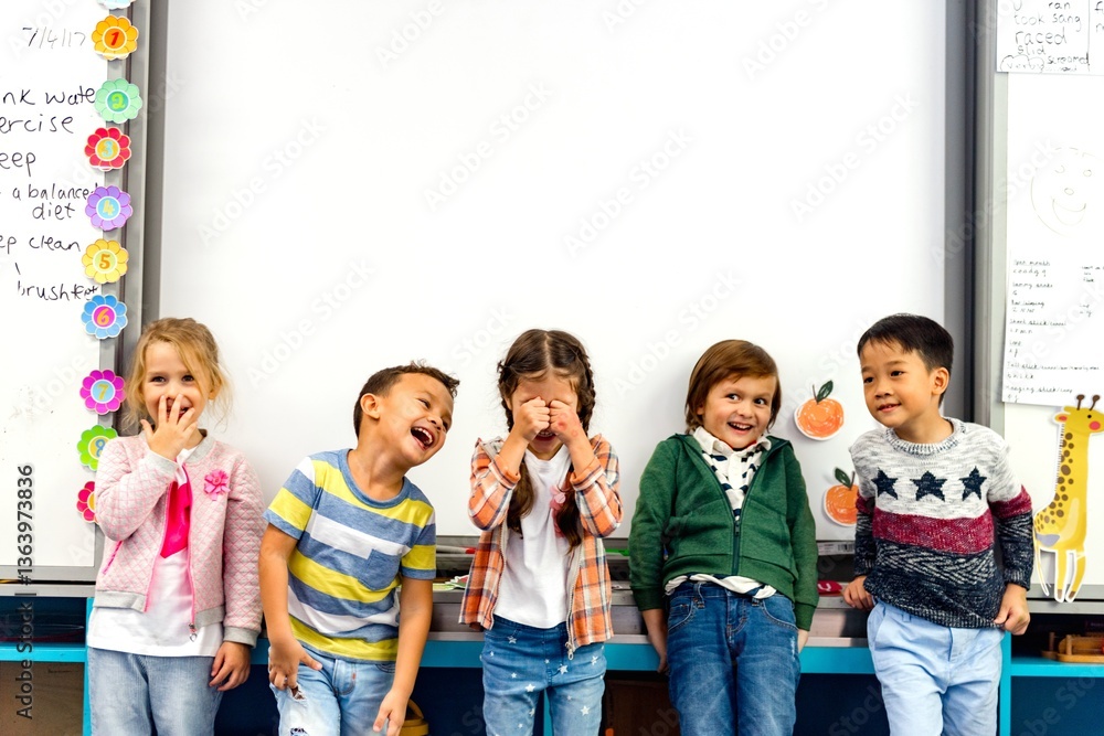 Group of diverse children laughing in a classroom. Kids stand in front of a whiteboard, smiling and playful. Happy children enjoying school time together. Cute little children in school.