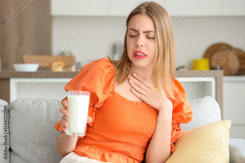 Quadro em tela Young woman with lactose intolerance sitting on sofa at home