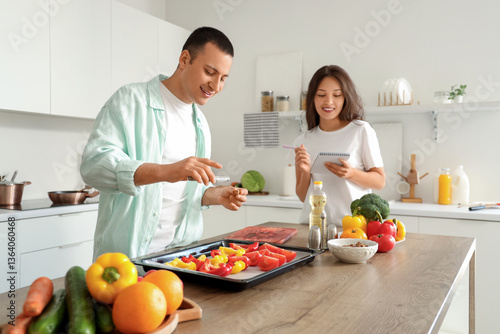 Young couple with recipe pe...