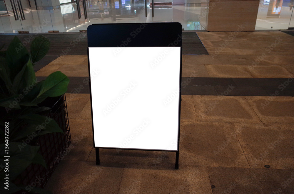 Blank white outdoor advertising stand or sandwich board mock up template. Clear street signage board placed by an outdoor dinning area of a restaurant. Background texture of standee on street.