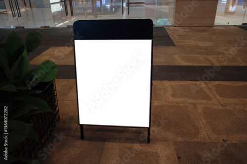 Obraz na płótnie Blank white outdoor advertising stand or sandwich board mock up template. Clear street signage board placed by an outdoor dinning area of a restaurant. Background texture of standee on street. w salonie