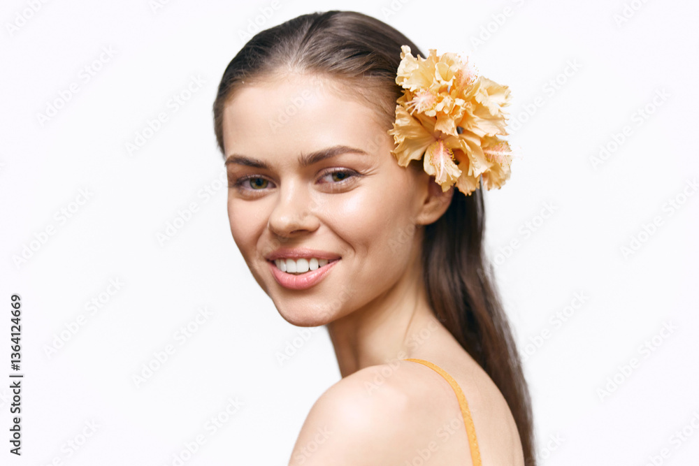 Fototapeta premium Beautiful young woman with a flower in her hair, showcasing a joyful smile and natural beauty, perfect for beauty and fashion concepts.