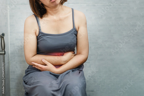 Quadro em tela woman sitting in toilet holding  stomach pain, suffering from diarrhea, ibs, or