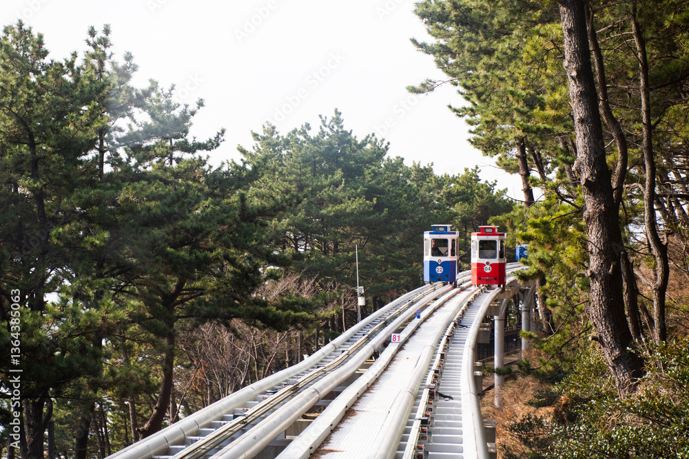 Naklejka premium Korean people and foreign travelers sitting passengers journey on Sky Capsule Tram Haeundae Blue Line at Mipo Station for travel visit in Haeundae Beach Park at Haeundae gu city in Busan, South Korea