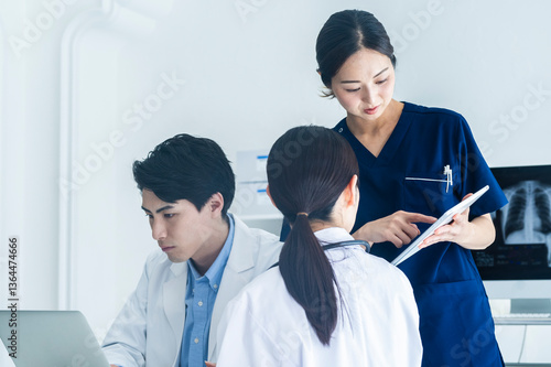 Doctors Reviewing Patient Charts with a Nurse Using a Tablet
A doctor points to a document while discussing medical records with a nurse using a tablet in a clinical setting.