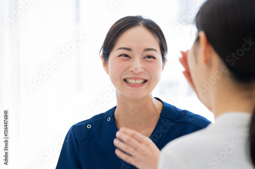 Obraz na płótnie Nurse and patient sharing a smile during appointment
Description: A nurse in blue scrubs smiling warmly at a patient during a lighthearted moment in a clinical environment. w salonie