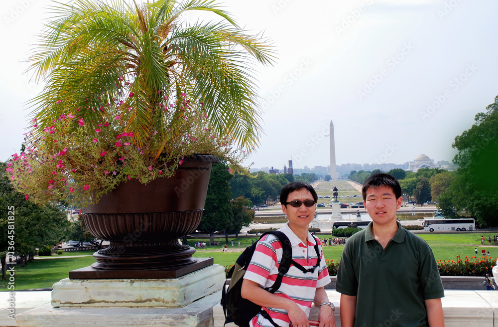 Tourists posing for photos with the Washington Monument on the National Mall in the distance. Washington D.C.