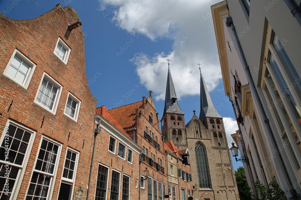 Obraz premium Traditional historic medieval houses, located in the neighborhood Bergkwartier of Deventer, Overijssel, Netherlands, with the two towers of Saint Nicholas church