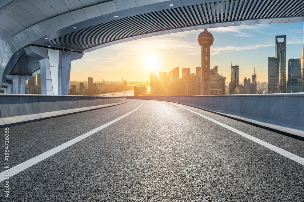 Empty asphalt road leading to the Shanghai skyline during sunrise