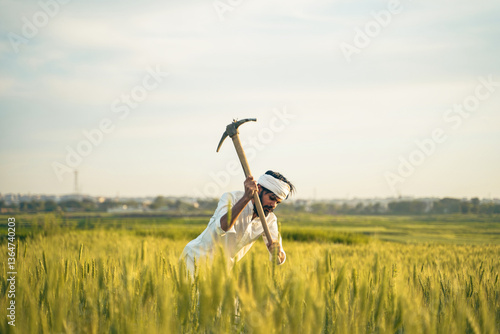 Φωτογραφία A hardworking Pakistani Indian farmer in traditional white clothing raises a pickaxe while working in a lush green wheat field under the open sky
