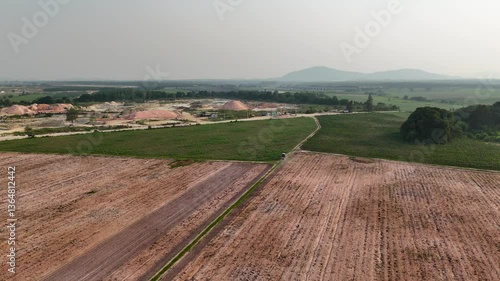Aerial View of Agricultural Landscape Fields, Hills, and Construction Amidst Natures Greenery in Rural Earth, Showcasing Harmony Between Human Activity and Tranquil Environment.