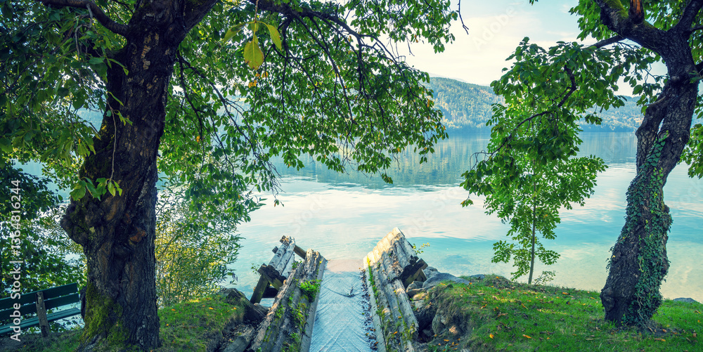View of a mountain lake in autumn. Millstatt am See. The Mühlbach stream flows into Lake Millstatt in Carinthia, Austria, Europe